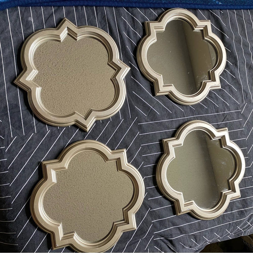 Four small decorative mirrors.
